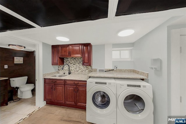 washroom featuring a sink, laundry area, and washer and clothes dryer