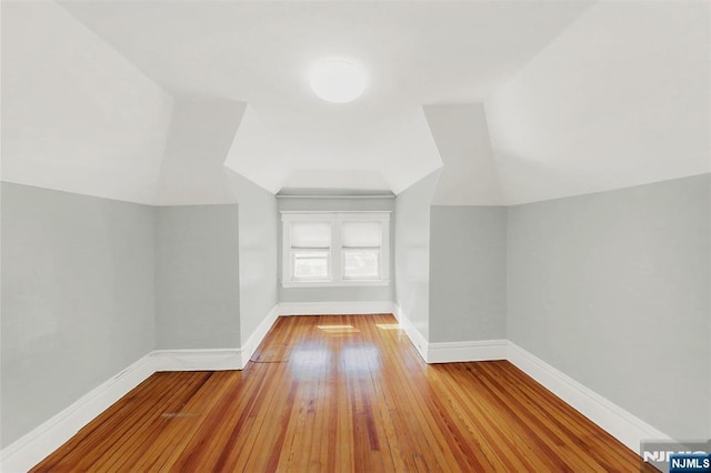 bonus room with lofted ceiling, baseboards, and wood-type flooring