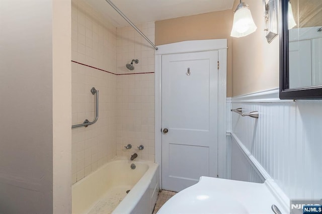 full bathroom with wainscoting and shower / tub combination