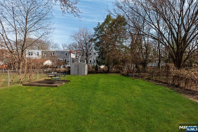 view of yard featuring a fenced backyard, a storage shed, and an outdoor structure