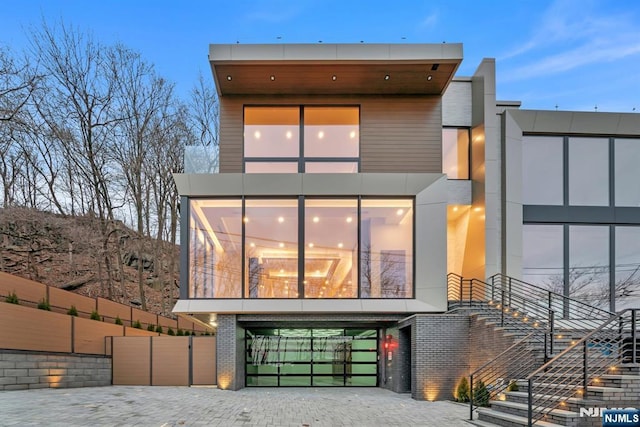 modern home featuring brick siding and a balcony