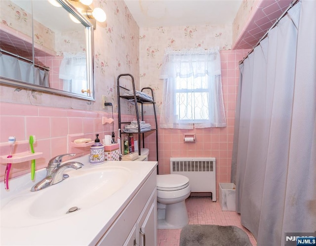 bathroom with vanity, radiator, wallpapered walls, tile walls, and toilet