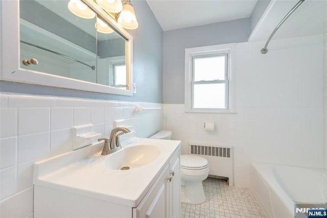 full bath featuring toilet, radiator, tile walls, wainscoting, and vanity