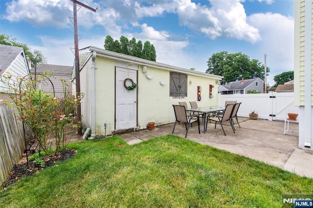 back of house featuring a patio area, a lawn, a fenced backyard, and a gate