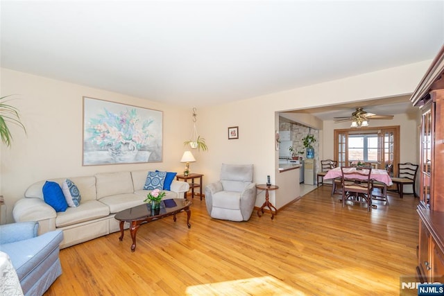 living area with light wood-style floors and ceiling fan