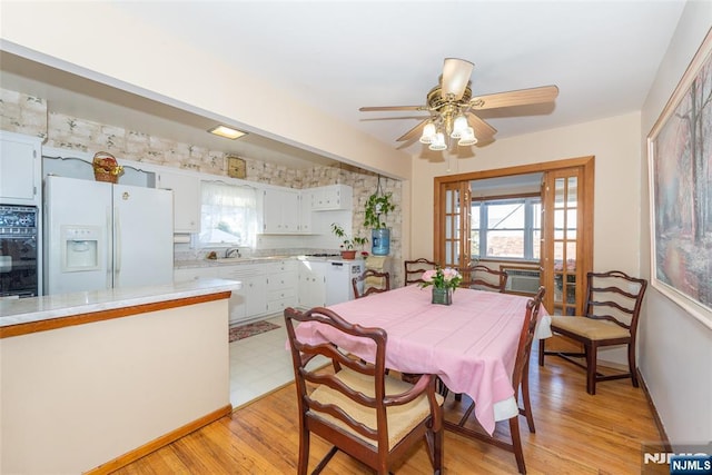 dining room with a wealth of natural light, light wood-style flooring, and ceiling fan