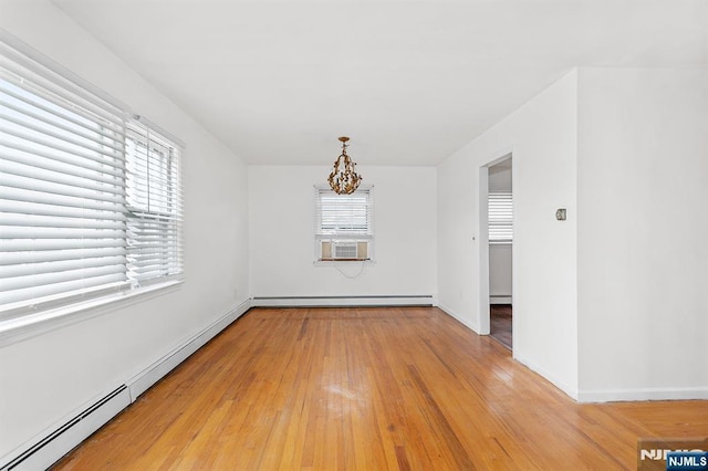 unfurnished dining area with a baseboard heating unit, baseboard heating, light wood-style flooring, cooling unit, and an inviting chandelier