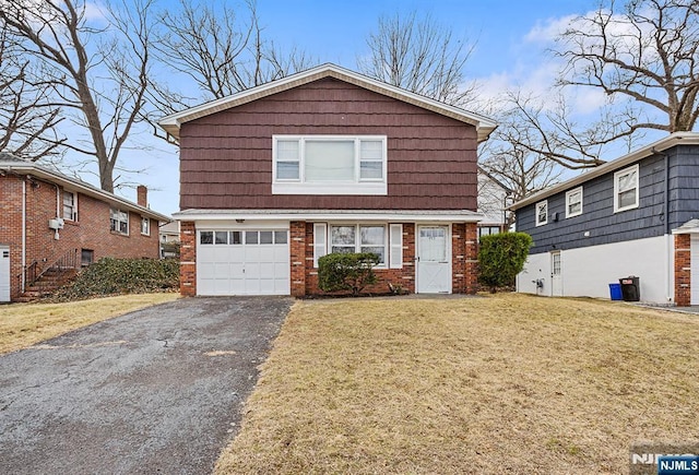 traditional-style home with a front lawn, brick siding, a garage, and driveway