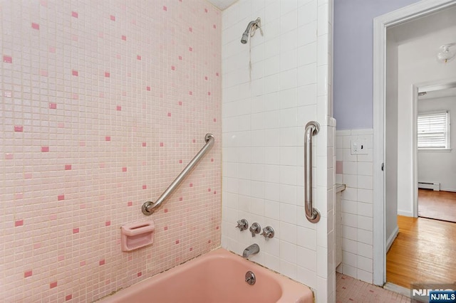 bathroom featuring tile walls,  shower combination, and a baseboard radiator