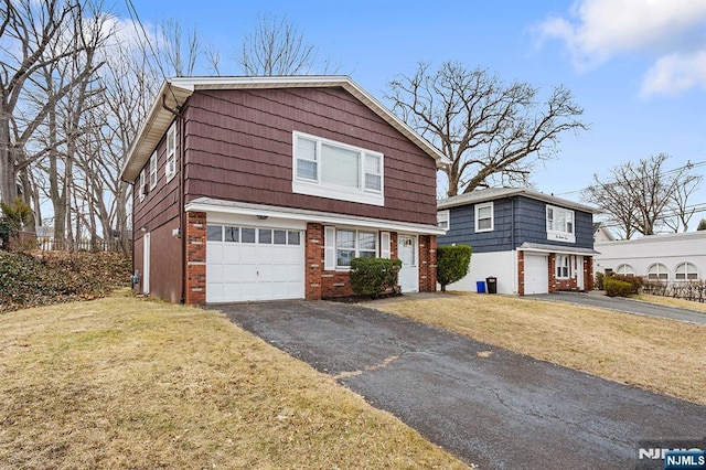 view of front of house featuring brick siding, a front lawn, an attached garage, and driveway