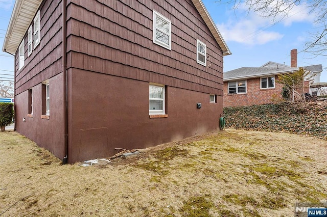 view of side of home with a yard