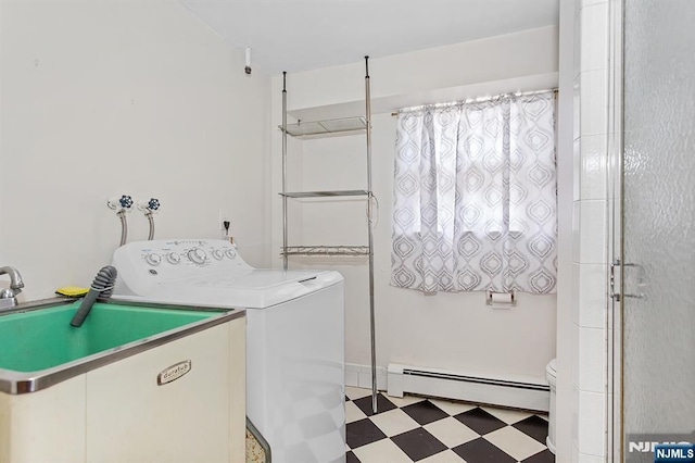 washroom with separate washer and dryer, light floors, a baseboard heating unit, and a sink