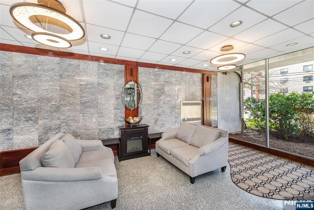 living area featuring a drop ceiling, recessed lighting, and a wall of windows