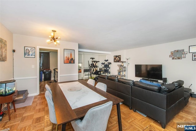 dining space with baseboards and a chandelier