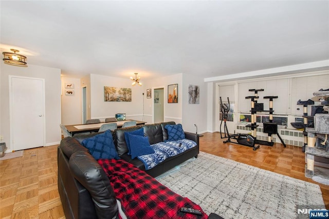 living room featuring a notable chandelier and baseboards