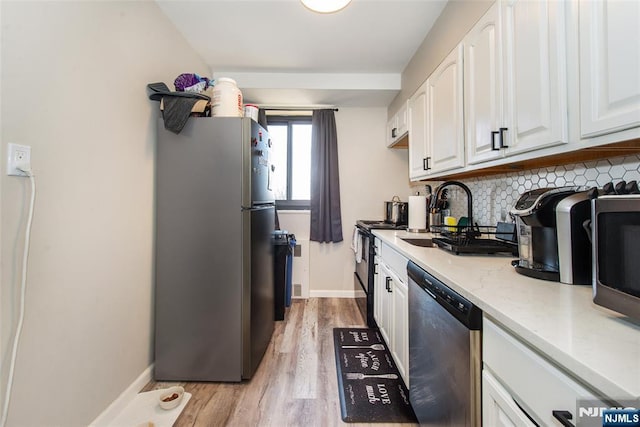 kitchen featuring decorative backsplash, appliances with stainless steel finishes, white cabinetry, and a sink