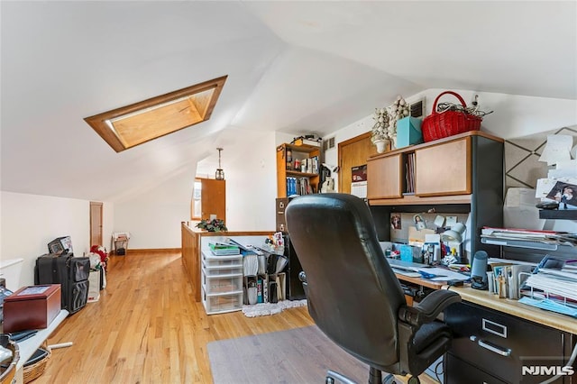 office space featuring lofted ceiling with skylight and light wood-type flooring