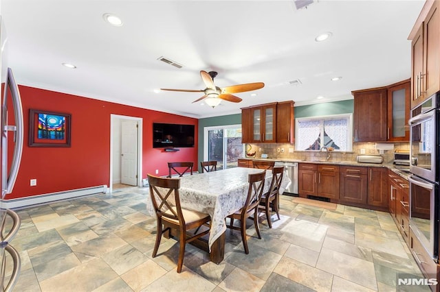 dining room featuring baseboard heating, a ceiling fan, crown molding, and visible vents