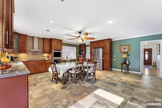 kitchen with tasteful backsplash, baseboards, ceiling fan, wall chimney range hood, and stainless steel appliances