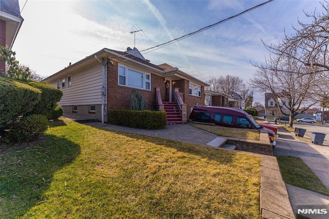 bungalow-style home featuring a front yard and brick siding