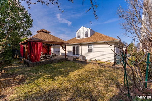 rear view of property with a patio, cooling unit, fence, a gazebo, and a lawn