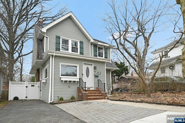 17 Cottage Pl, Leonia, NJ 07605 - view of front facade with a gate, a chimney, asphalt driveway, and entry steps