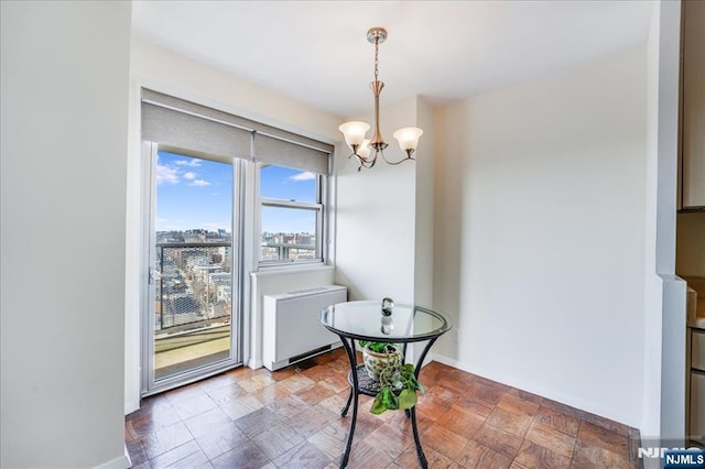 dining room with a city view, an inviting chandelier, radiator heating unit, and baseboards