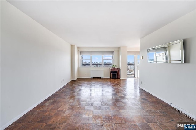 unfurnished living room with baseboards