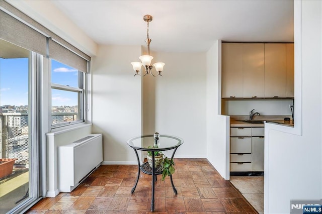 dining area featuring a notable chandelier, radiator heating unit, and baseboards