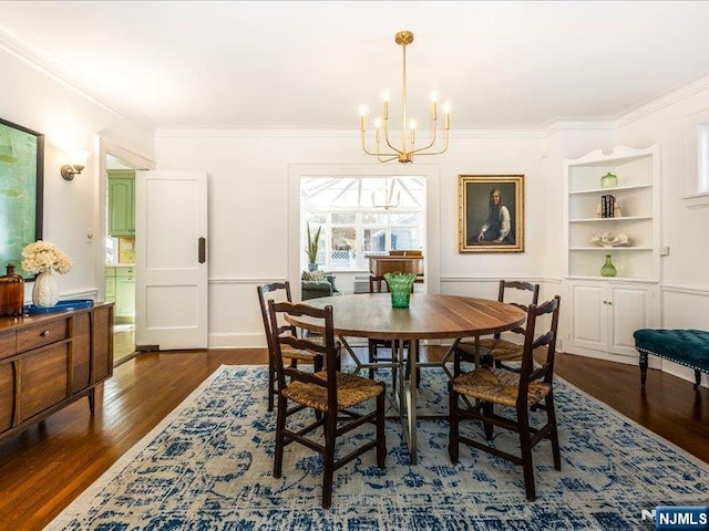 dining area with baseboards, crown molding, an inviting chandelier, and wood finished floors