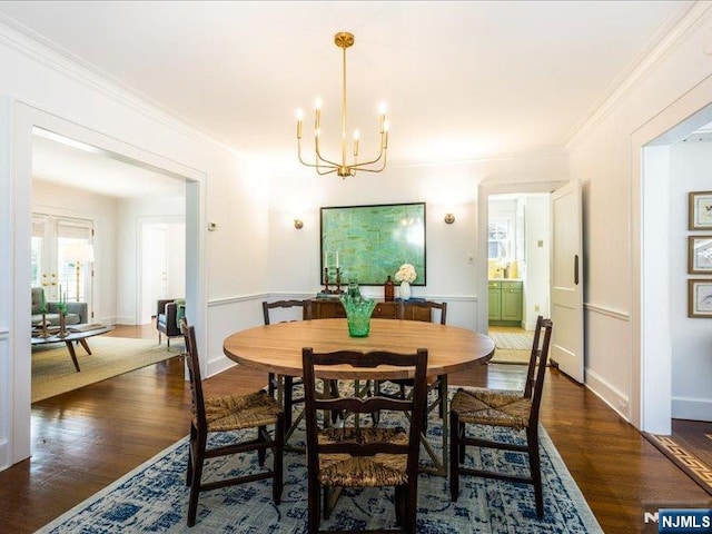 dining room featuring crown molding, a notable chandelier, and dark wood-style flooring