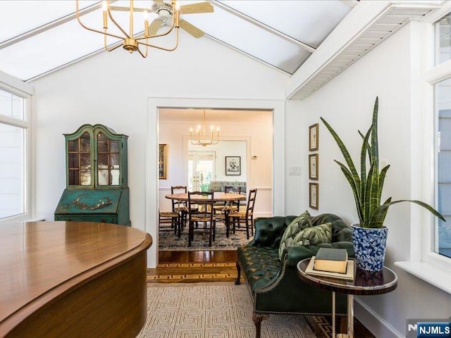 living room featuring lofted ceiling, an inviting chandelier, and wood finished floors