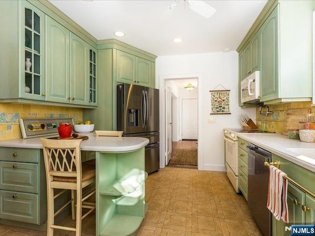 kitchen with green cabinetry, stainless steel appliances, and light countertops