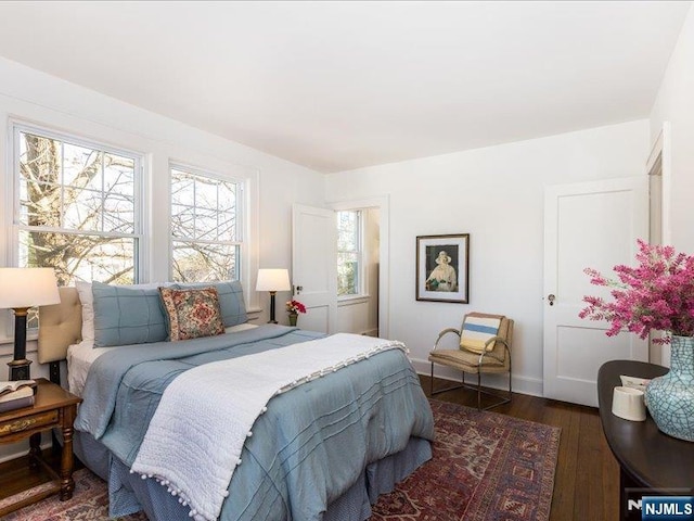 bedroom with baseboards and wood finished floors