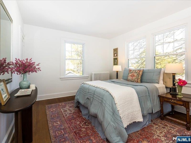 bedroom featuring radiator, wood finished floors, and baseboards