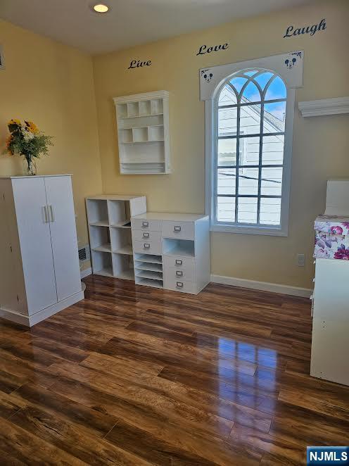 unfurnished bedroom with wood finished floors and baseboards