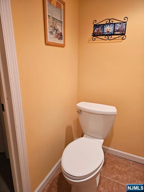 bathroom with toilet and baseboards