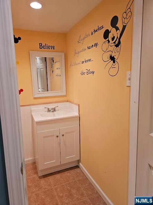 bathroom with baseboards, vanity, and tile patterned flooring