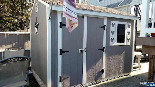 view of shed featuring fence