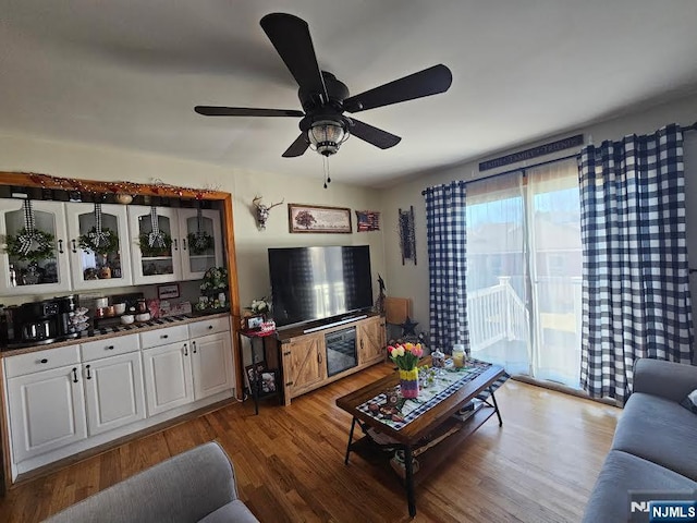 living area with wood finished floors and ceiling fan