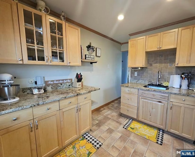 kitchen with backsplash, ornamental molding, light brown cabinetry, and a sink