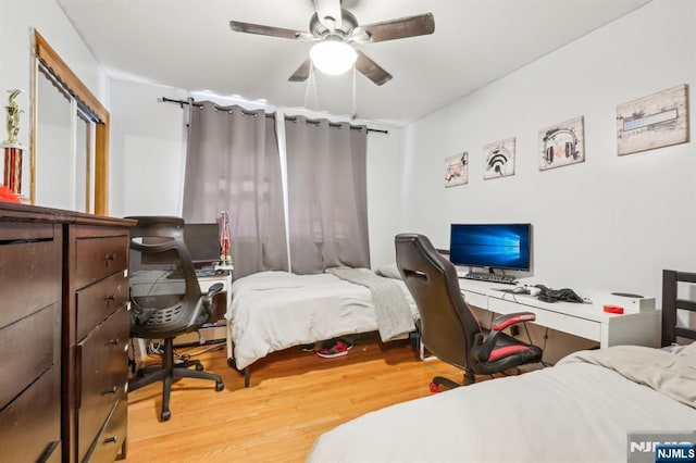 bedroom with a closet, light wood-style flooring, and a ceiling fan