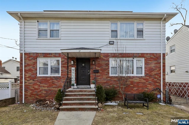 view of front of property with fence and brick siding