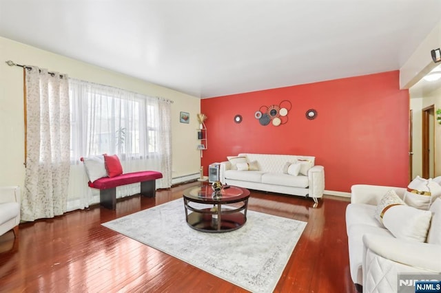 living room featuring an accent wall and wood finished floors