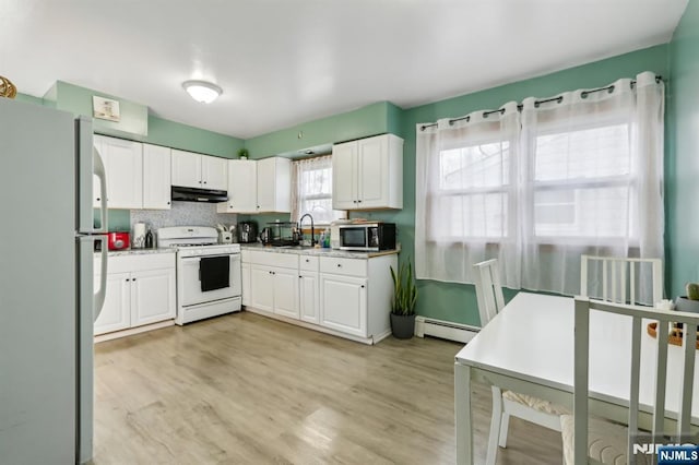 kitchen with a baseboard heating unit, white appliances, white cabinets, and under cabinet range hood