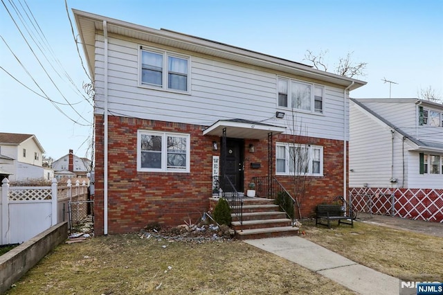 view of front of property with brick siding and fence