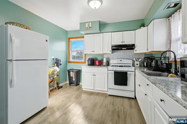 kitchen featuring under cabinet range hood, light wood-style flooring, white cabinets, white appliances, and a sink