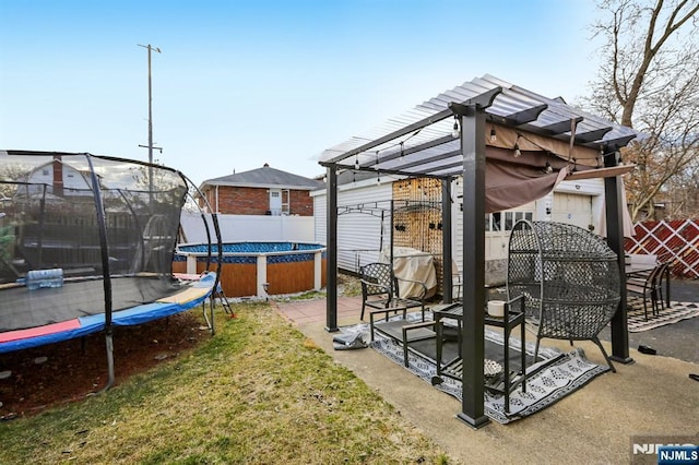 view of yard with a patio, a trampoline, and fence