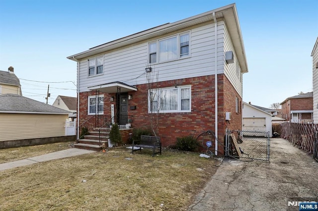 view of front facade featuring brick siding and fence