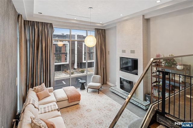 living area featuring recessed lighting, baseboards, and a large fireplace